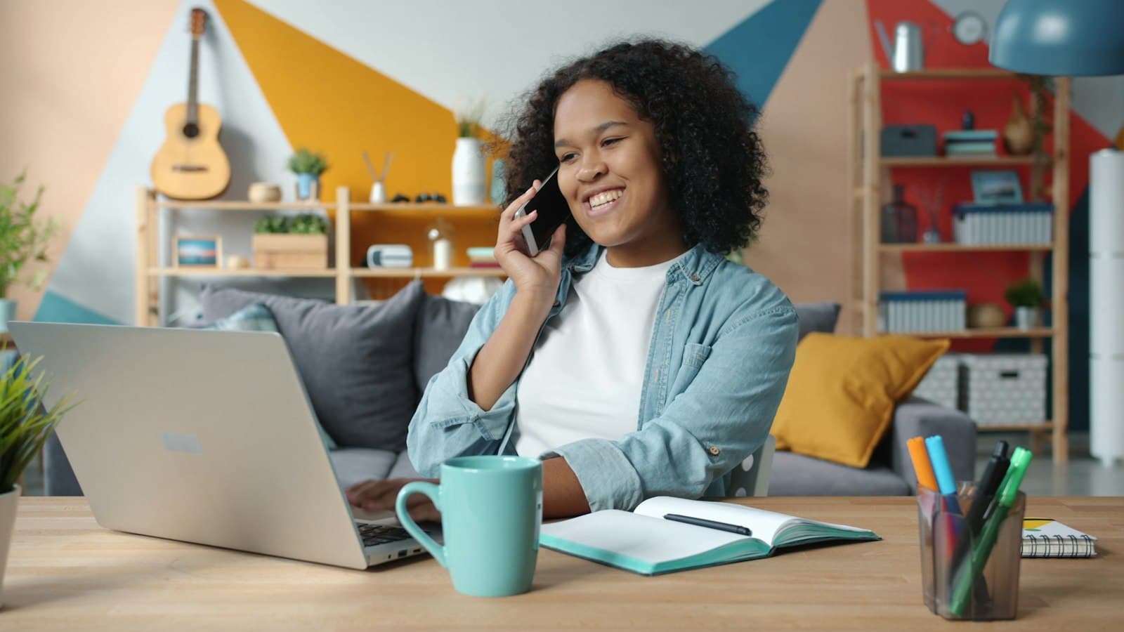 A woman on a phone call while working on a laptop