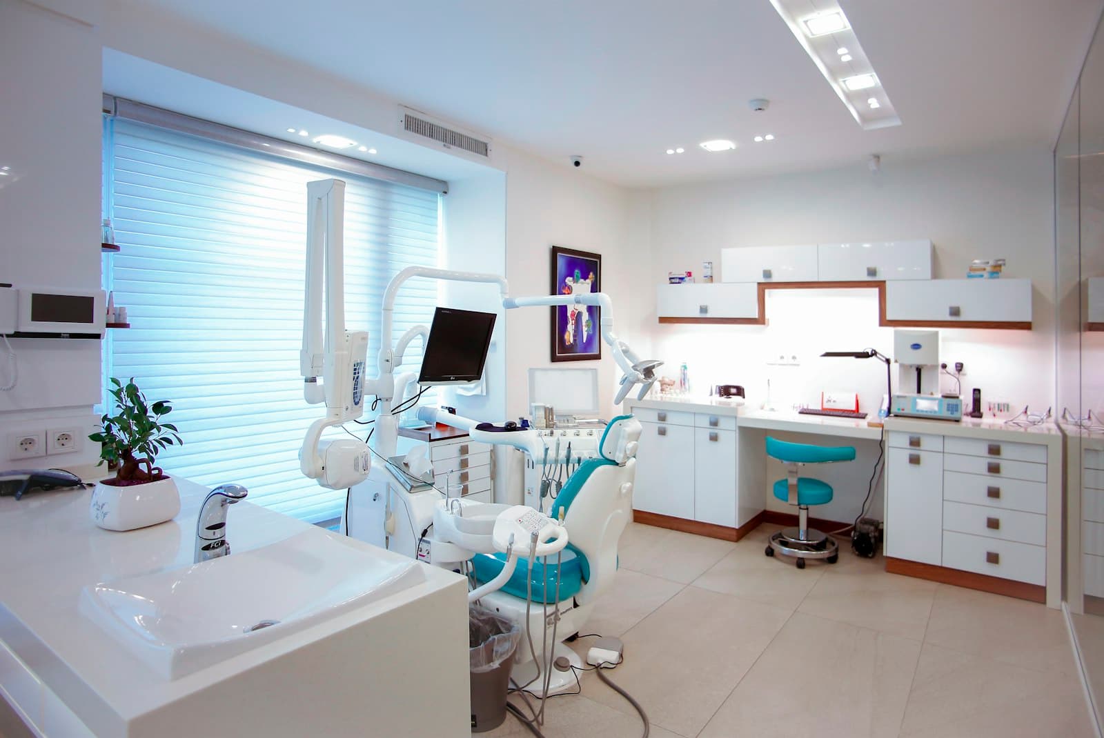A clean, modern dental surgery with a patient chair and equipment